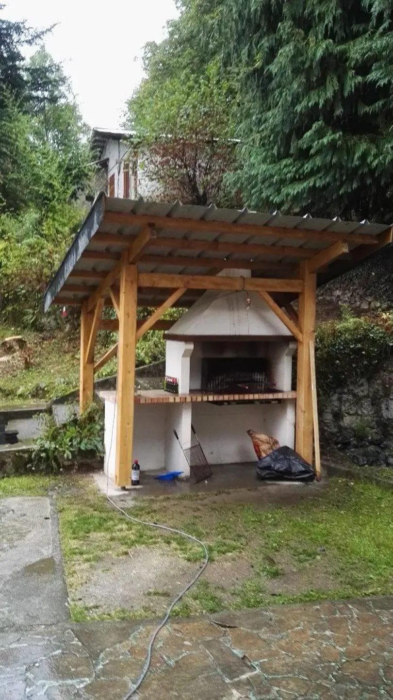 Coin repas couvert et barbecue dans le jardin du chalet
